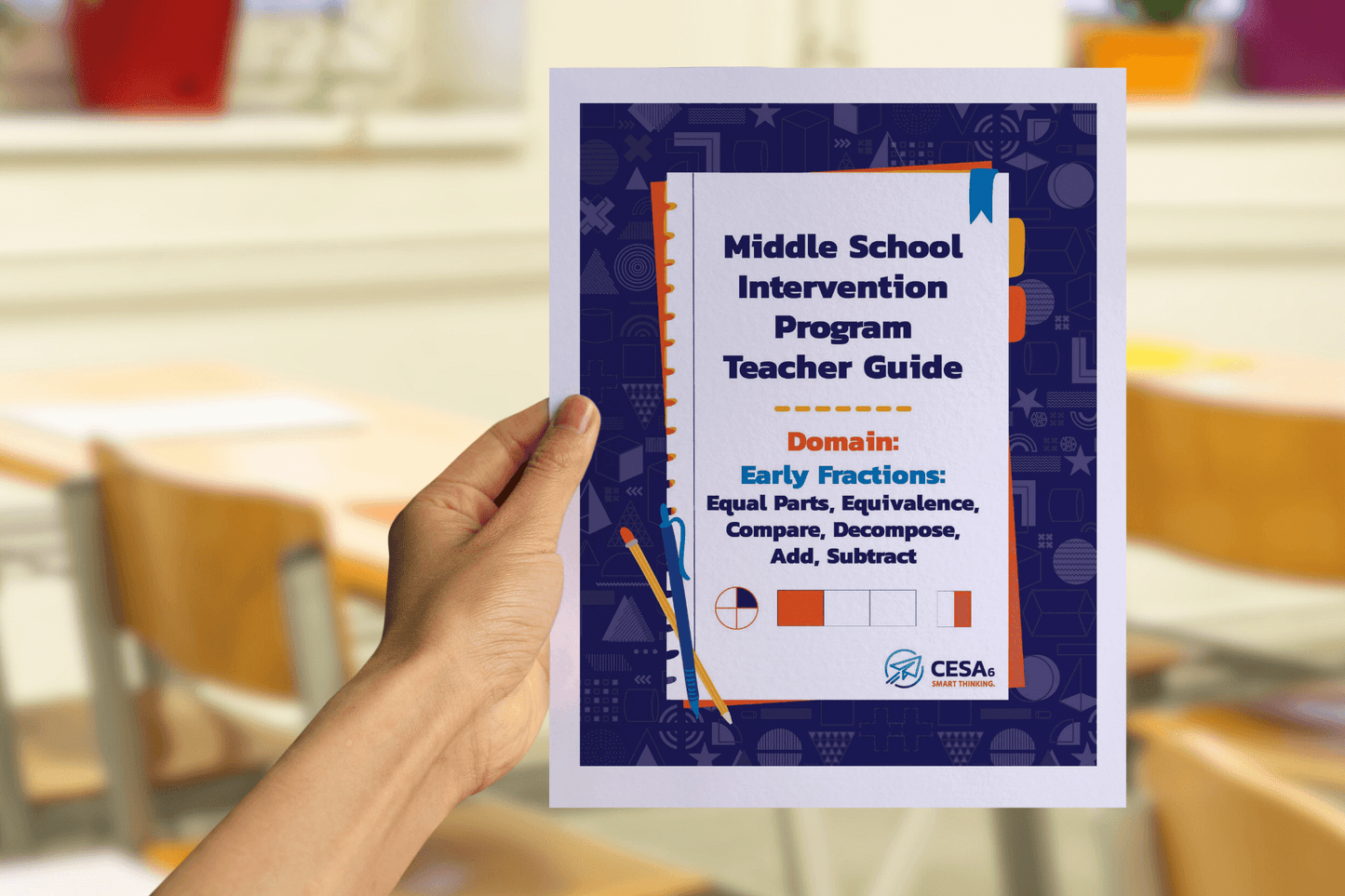 A hand holds a booklet titled “Middle School Intervention Program Teacher Guide – Domain: Early Fractions: Equal Parts, Equivalence, Compare, Decompose, Add, Subtract.” The cover features a blue patterned border with orange and blue accents. Simple fraction graphics, including a circle divided into fourths and shaded bar models, are displayed at the bottom. The CESA 6 logo is shown in the lower corner. The blurred background shows a classroom with wooden chairs, tables, and colorful plant pots.