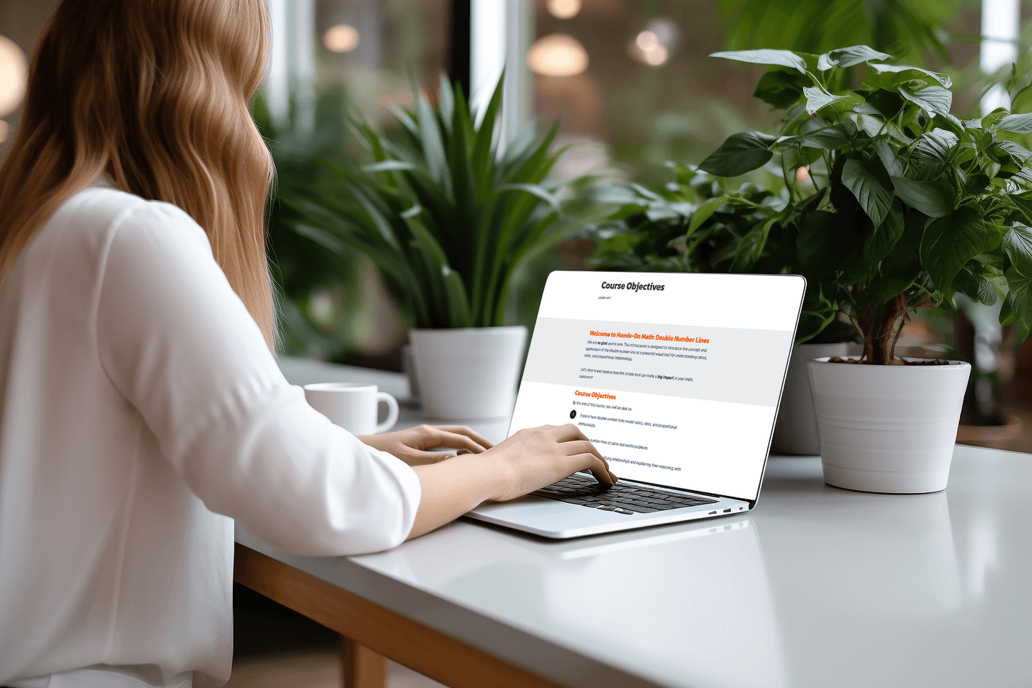 Woman in white blouse using a laptop on a bright table with two potted plants, viewing a document titled "Course Objectives," in a serene office space.