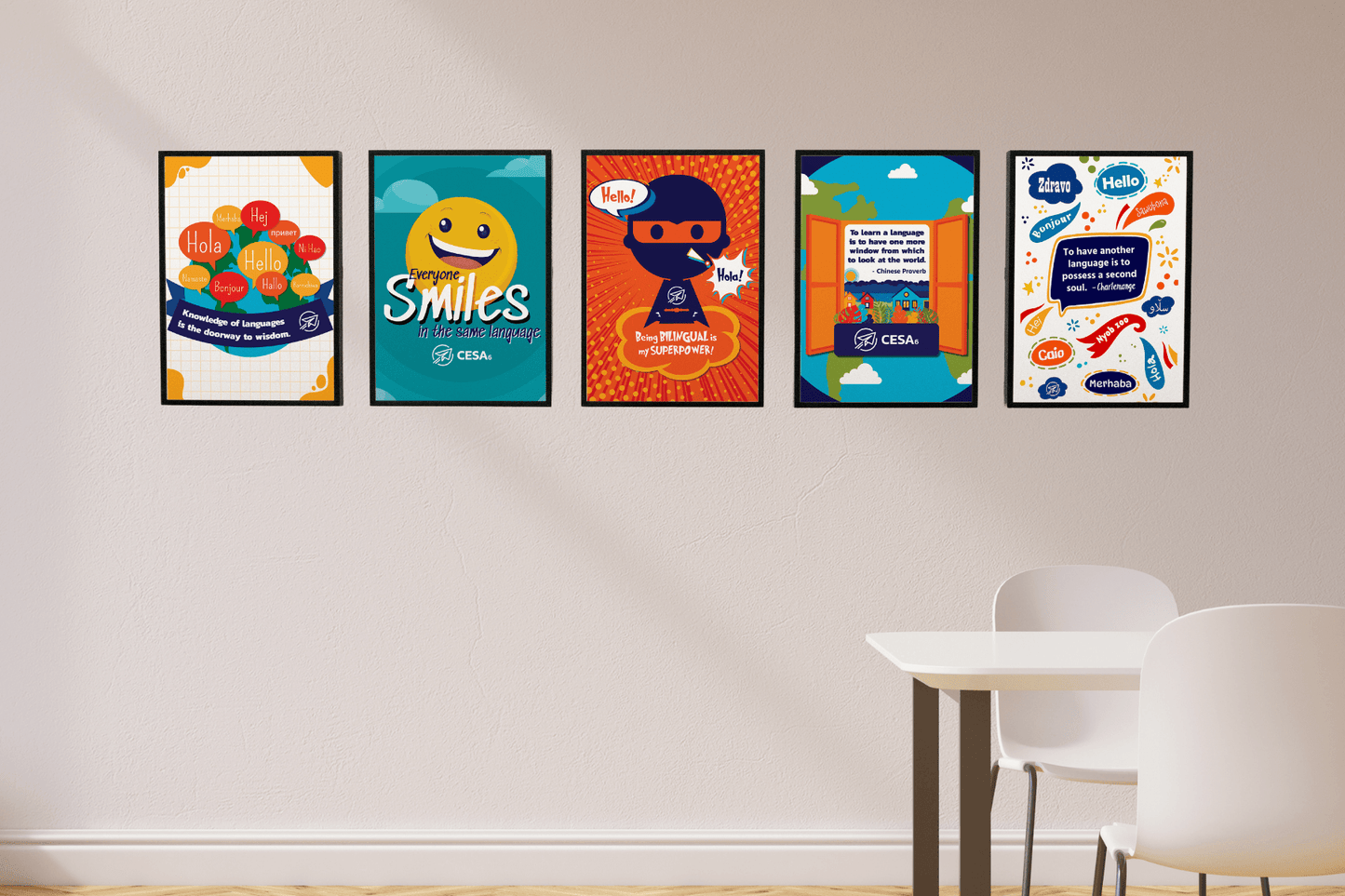This image shows five colorful posters displayed in a row on a light-colored wall, each highlighting the power of language and cultural connection. The posters feature messages such as “Knowledge of languages is the doorway to wisdom,” “Everyone Smiles in the Same Language,” “Being Bilingual is my Superpower!” “To learn a language is to have one more window from which to look at the world,” and “To have another language is to possess a second soul.”
