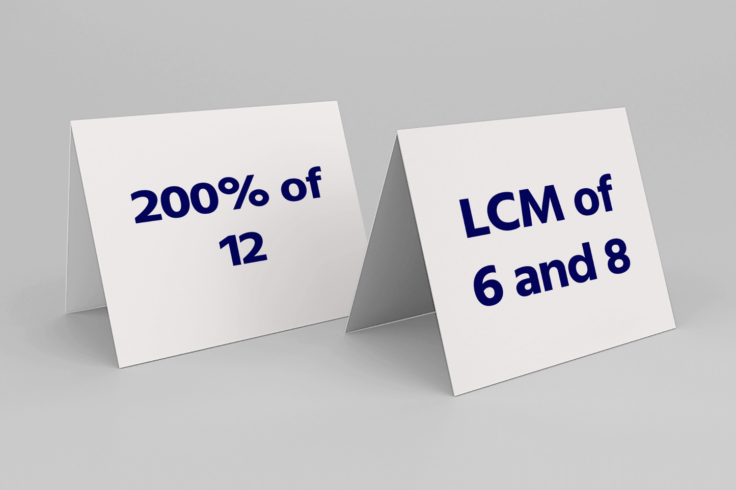 Two white tent cards on a gray surface show math problems: "200% of 12" and "LCM of 6 and 8" in bold blue text, suggesting a learning setting.