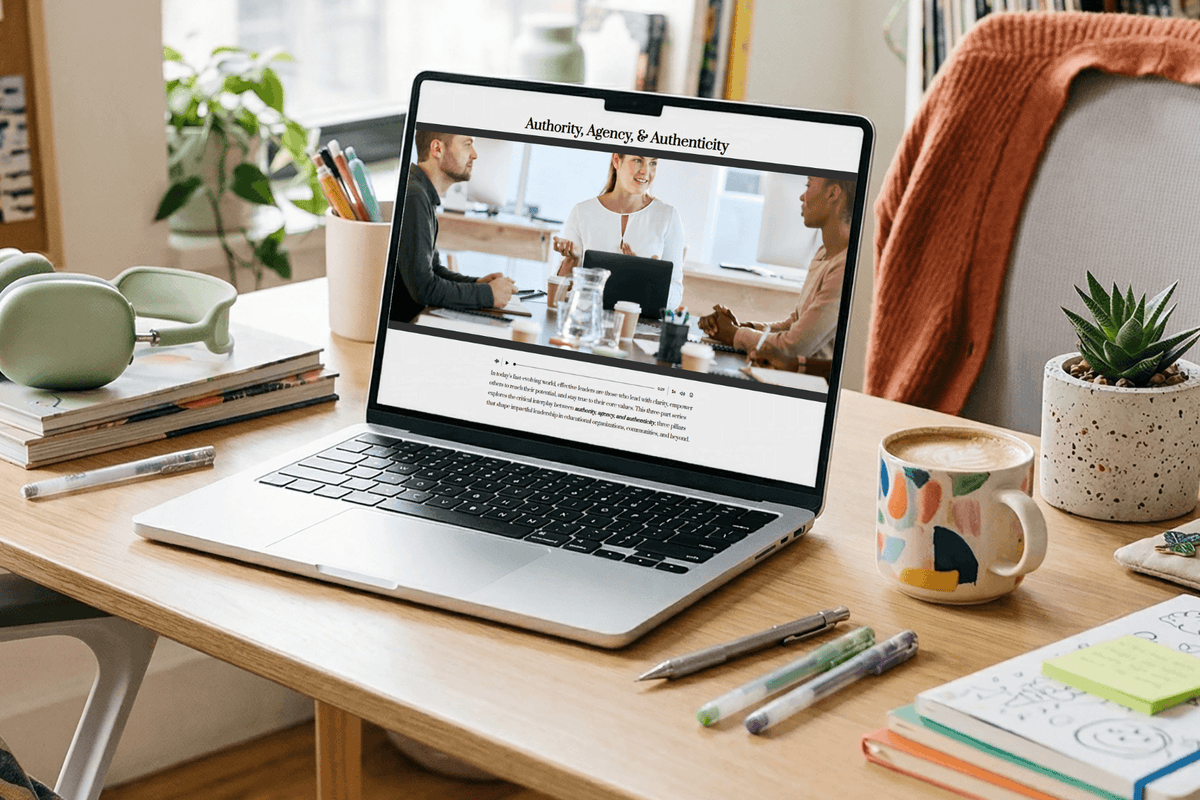 A laptop displays a business meeting webpage titled “Authority, Agency & Authenticity” on a tidy wooden desk with books, pens, a mug, and a succulent.