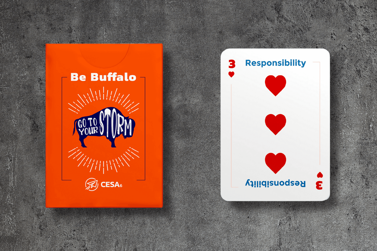 A "Be Buffalo" card deck box next to a card displaying the word "Responsibility" with three red hearts.