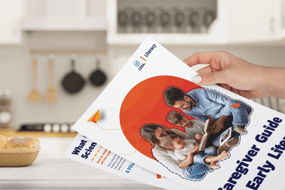 A person holding the printed version of the digital 'Caregiver Guide to Early Literacy' booklet, designed with high-contrast text, clear fonts, and engaging visuals. The cover features a diverse family reading together, promoting inclusive literacy practices in an accessible format.