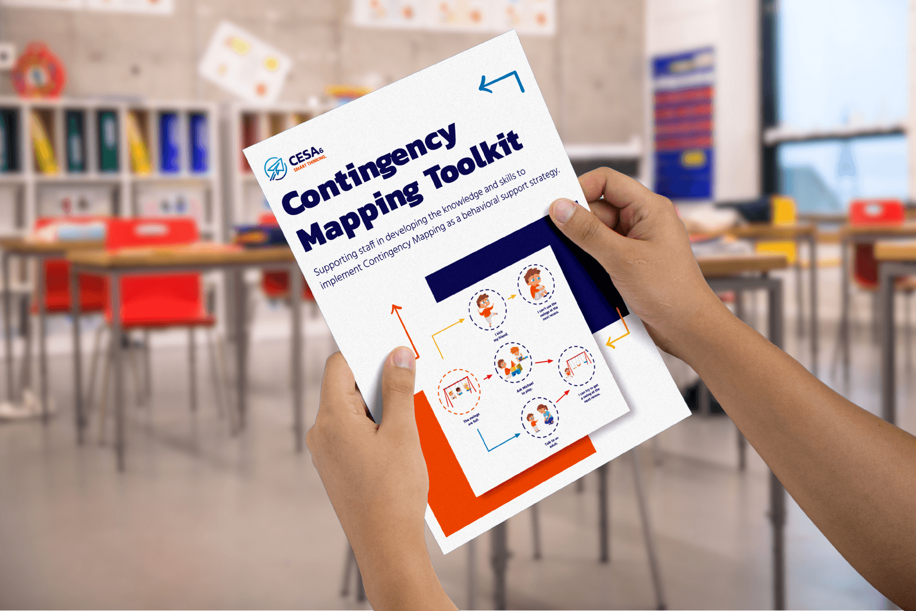 Hands holding a "Contingency Mapping Toolkit" booklet in a classroom. The cover shows diagrams and text in a colorful, professional design.