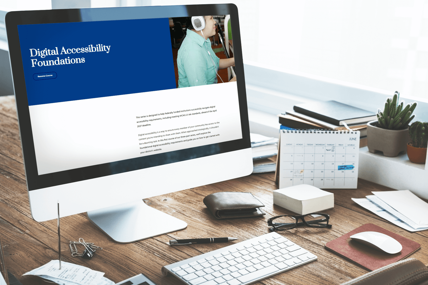 A neatly arranged desk with a computer displaying a webpage titled "Digital Accessibility Foundations." The scene conveys a professional and organized atmosphere.