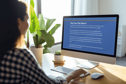 A person in a checkered shirt is sitting at a desk, viewing a computer screen displaying a webpage titled "Why Does This Matter?" Sunlit room with plants.