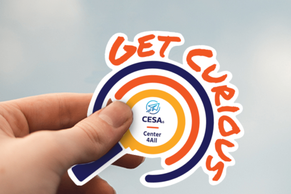 A hand holding a "GET CURIOUS" sticker with a spiral design and the CESA6 Center 4All logo in the center.