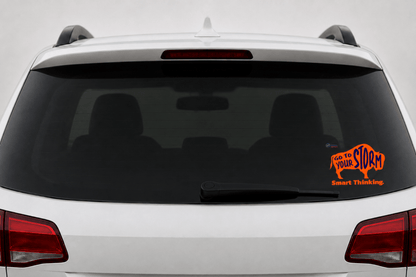 Rear view of a white SUV with a transparent static cling displayed on the lower right corner of the rear window. The cling features an orange buffalo with the words "GO TO YOUR STORM" in dark blue, the phrase "Smart Thinking." in orange, and the CESA 6 logo.