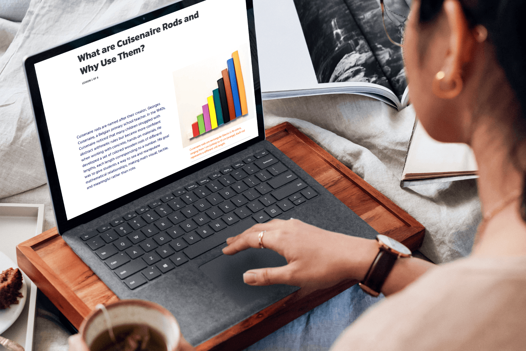 A person reads an article on a laptop titled "What are Cuisenaire Rods and Why Use Them?" The screen shows colorful Cuisenaire Rods.