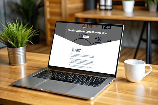 Laptop on a wooden table displaying a webpage titled "Hands-On Math: Open Number Line." The setting is a cozy indoor workspace with a plant and a white mug, conveying an organized and focused atmosphere.