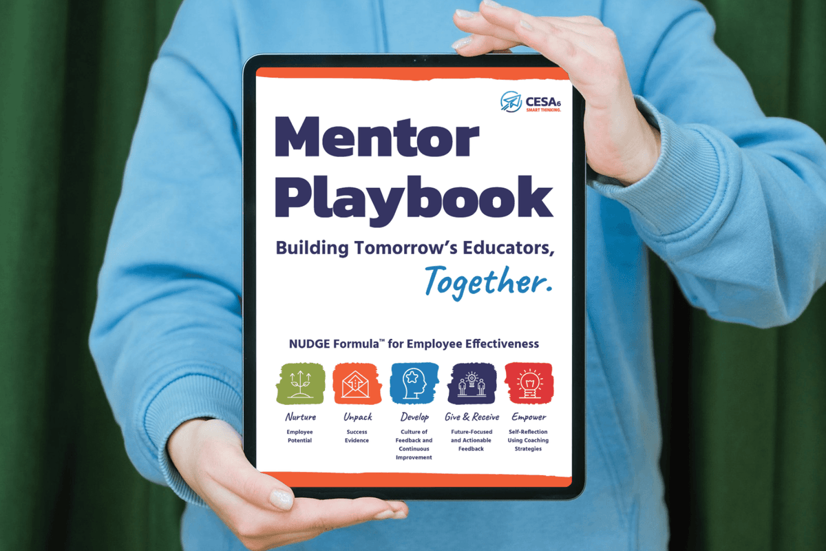 A person in a light blue sweatshirt holds a tablet displaying the cover of the 'Mentor Playbook' by CESA 6. The tablet screen shows the title 'Mentor Playbook' with the subtitle 'Building Tomorrow's Educators, Together.