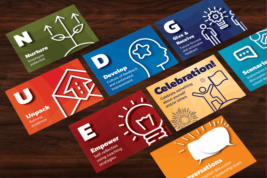 Collage of colorful cards on wood: "Nurture" with plant, "Develop" with head, "Unpack" with house, "Empower" with bulb, "Celebration!" with figures, and "Conversations" with speech bubbles.