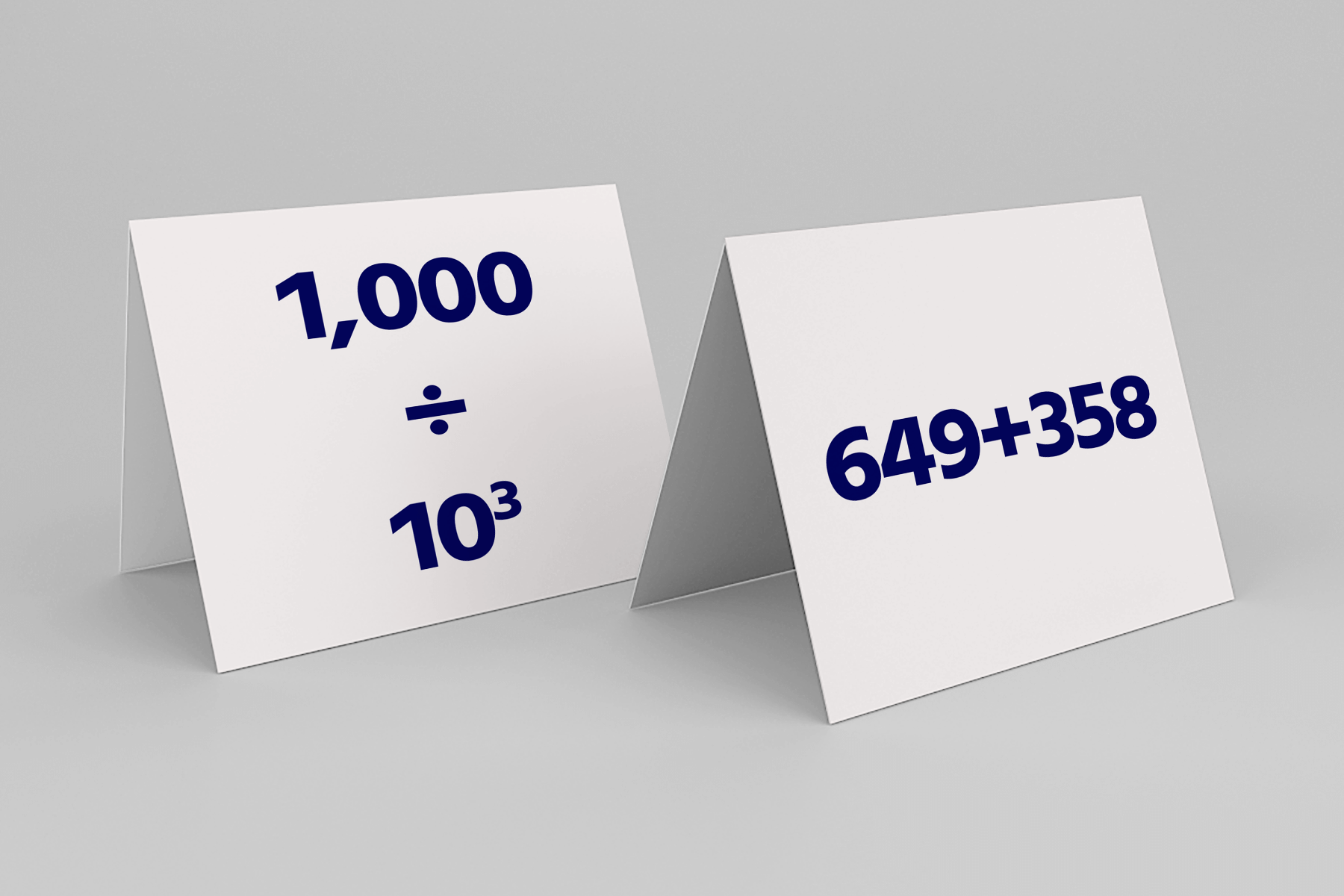 Two tent-style math cards are displayed. The card on the left shows the expression "1,000 ÷ 10³" in large dark blue text, representing division by a power of ten. The card on the right displays the addition equation "649 + 358" in matching bold dark blue text.