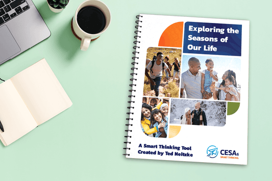 A spiral-bound workbook titled "Exploring the Seasons of Our Life" lies on a mint-green desk next to a laptop, open notebook, pen, coffee mug, and a small potted succulent. The cover of the workbook features a collage of diverse people across various stages of life—hiking, playing, embracing, and walking in the snow—symbolizing different "seasons" of life. The subtitle reads: "A Smart Thinking Tool Created by Ted Neitzke." The CESA 6 logo with the tagline “SMART THINKING.” is printed at the bottom right.